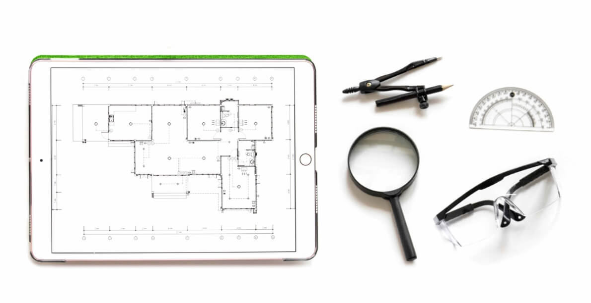 Foto di strumenti per disegno tecnico e progettazione: tablet, goniometro, lente di ingrandimento, occhiali e compasso.