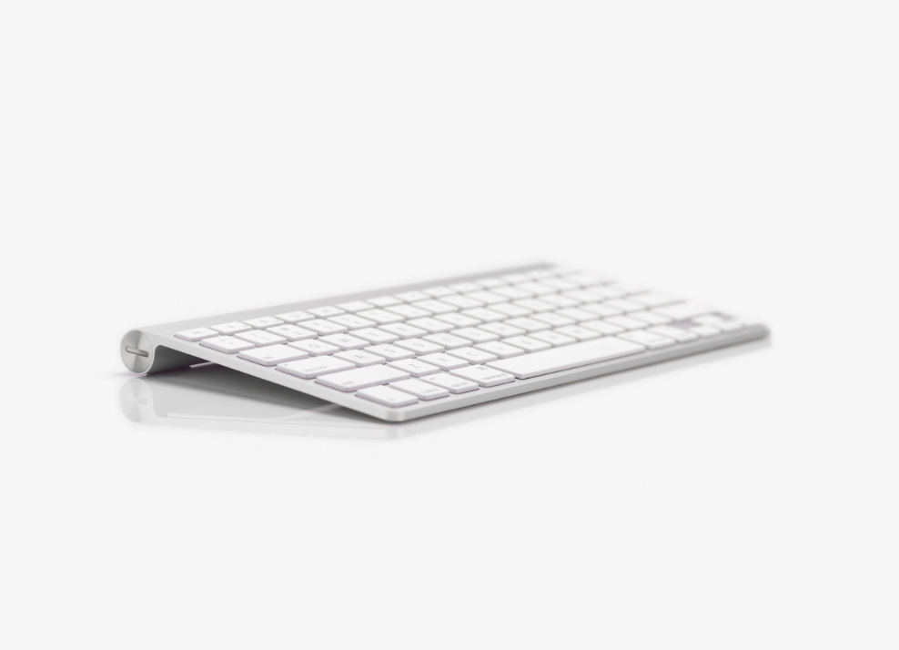 Foto di una tastiera per PC wireless su sfondo grigio.