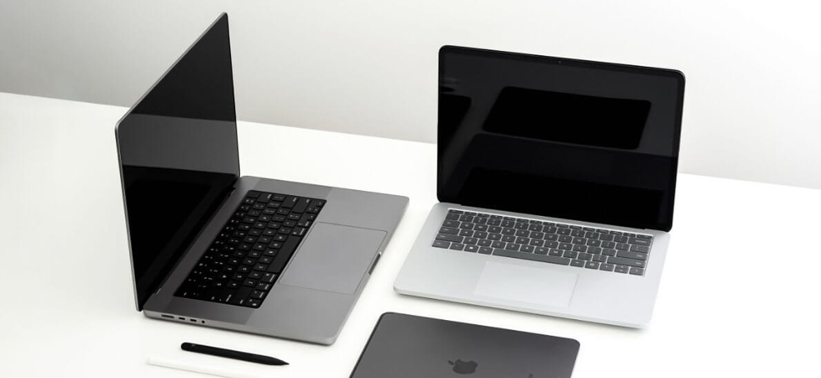 Foto di tre laptop disposti su un tavolo e con schermo aperto e chiuso.
