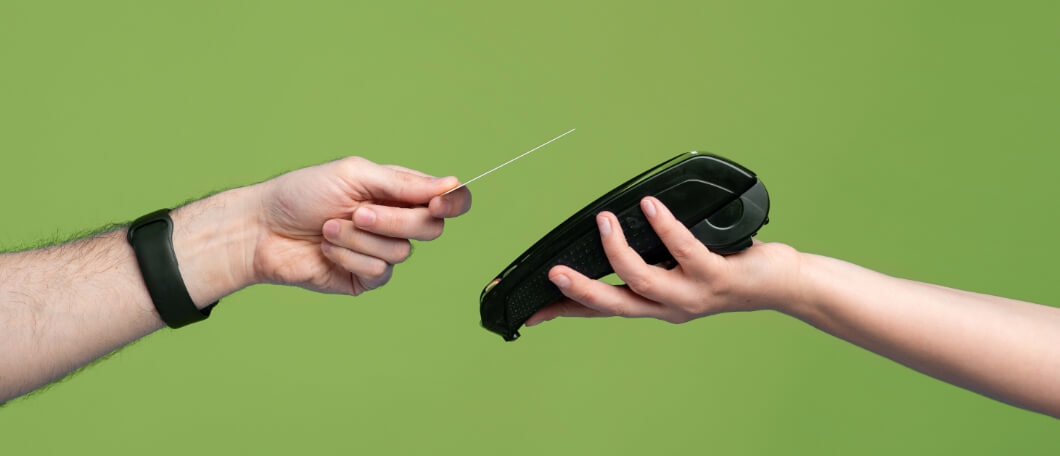 Foto di due mani che eseguono un pagamento elettronico con carta di credito e POS