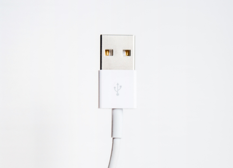 Foto di un cavo USB bianco su sfondo grigio. 
